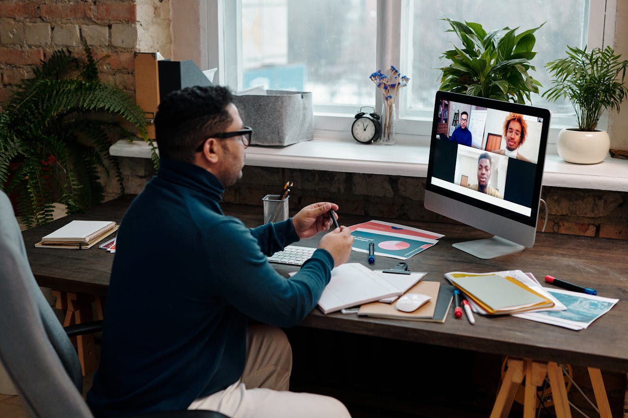 menu-03 Man engaging in an online meeting from home office, showcasing remote work dynamics.
